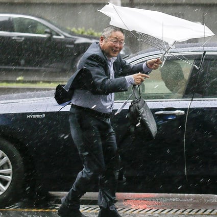 A businessman struggles with his umbrella during heavy rain in Tokyo,on Monday morning as Typhoon Phanfone strikes Japan. Photo: EPA