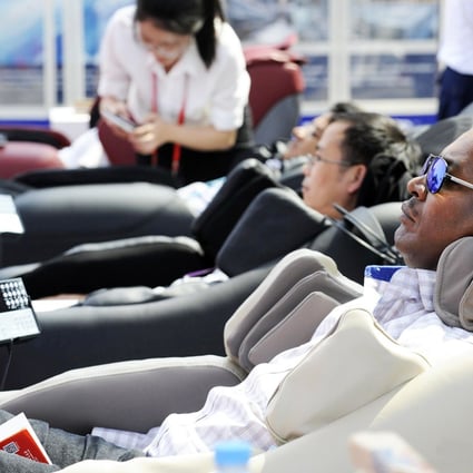 Buyers at the Canton Fair de-stress in massage chairs. Fears over Ebola and the economy may have hit attendance. Photo: Xinhua