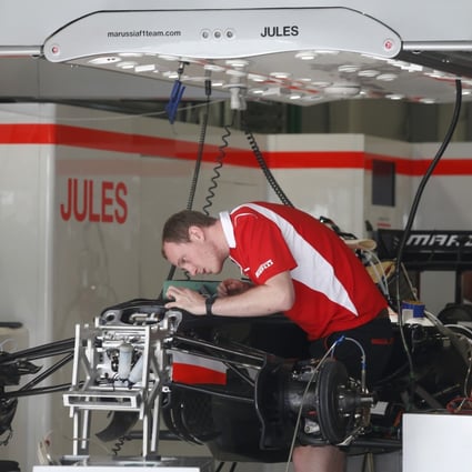 A Marussia mechanic works on a car in the Jules Bianchi garage at the Sochi Autodrom Formula One circuit. Photo: AP