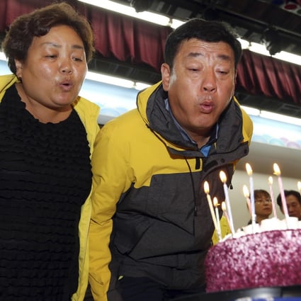 Hwang In-yeol and his wife, Shim Myeong-seop, blow out candles on a birthday cake for their late daughter Ji-hyeon. Photo: AP