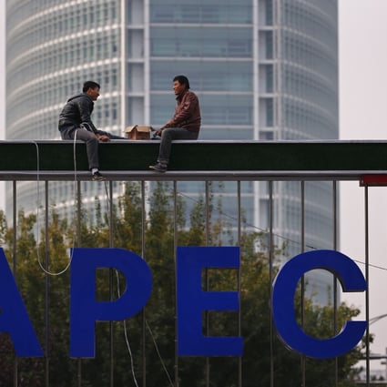 Workers install lighting on an APEC sign post at the financial district in Beijing. Photo: Reuters