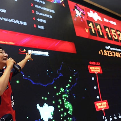 An employee at Alibaba headquarters in Hangzhou draws attention to the rising Double 11 sales. "Singles Day" is the mainland's busiest online shopping day. Photo: Xinhua
