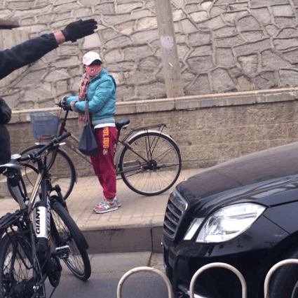 A Beijing cyclist gestures at a car illegally using the designated bike lane. Photo: Weibo