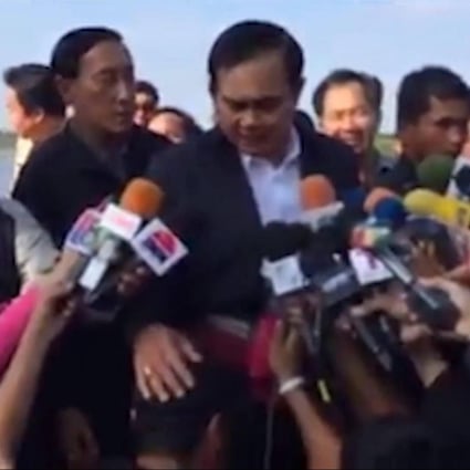Prime Minister Prayuth Chan-ocha pats the reporter's head.