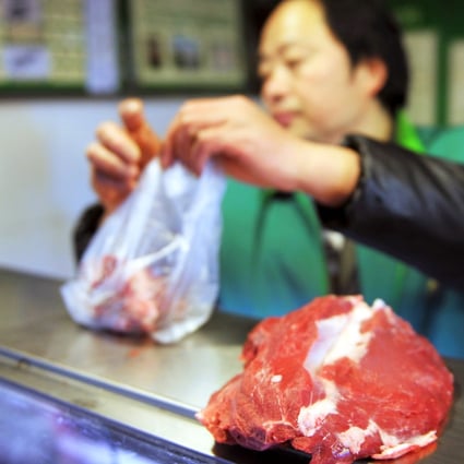 A vendor packages raw beef for sale in a market. Photo: AFP