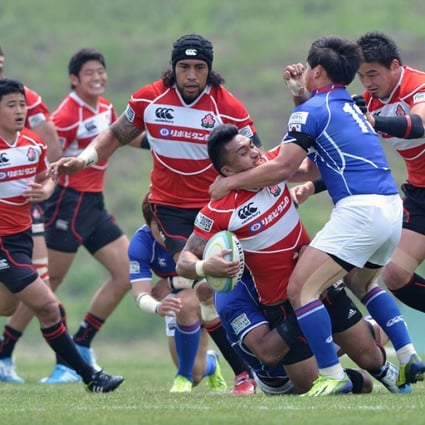 Male Sau of Japan fends off a South Korean defender during their Asian Five Nations clash in May this year. With the Top Five becoming a Top Three competition next year, these two teams and Hong Kong will meet more regularly. Photo: AFP