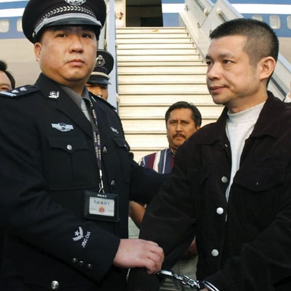 Fugitive suspect Yu Zhendong (right), suspected of stealing millions of yuan from a Chinese state-owned bank, is detained by Chinese police after being returned by United States authorities in 2004. Photo: AP