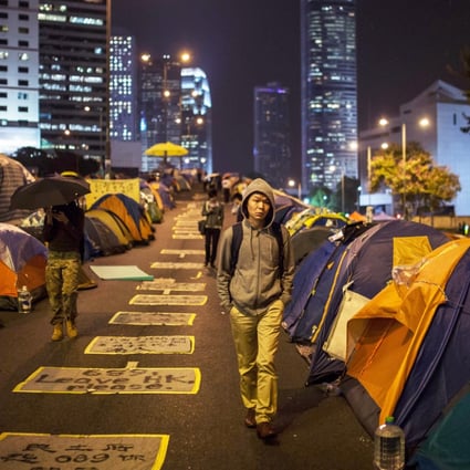 Pedestrians and protesters walk on a section of Harcourt Road, a multi-lane highway through the heart of the financial district currently blocked by pro-democracy protester barricades and hundreds of tents. Photo: AFP