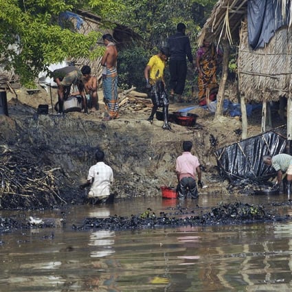 Bangladeshi villagers collect oil after tanker sank.Photo: AFP