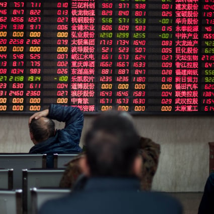 Investors look at stock information at a trading hall of a securities firm in Shanghai on December 10, 2014. Photo: AFP