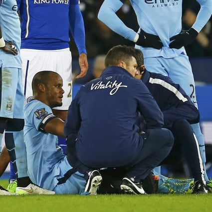 Vincent Kompany is assessed by medical staff after straining a hamstring during Manchester City's 1-0 win over Leicester City. Photo: Reuters