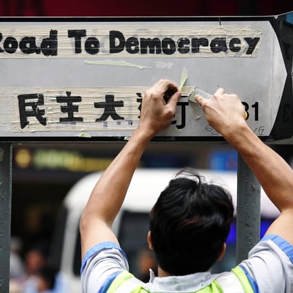 A worker cleans a road sign at the pro-democracy protest site in Causeway Bay. Photo: AFP
