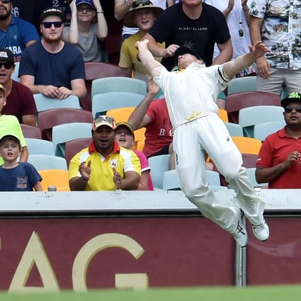 Australia's David Warner dives as he tries to take a catch on the boundary on day four of the second test against India. Photo: AFP