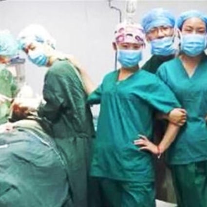 Say cheese: one of the photos of Chinese doctors and nurses taken during an operation at a Xian hospital, which sparked public anger. Photo: www.qianzhan.com