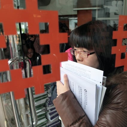 A woman collects an application form and documents for new flats on offer under the Home Ownership Scheme. Photo: Bruce Yan