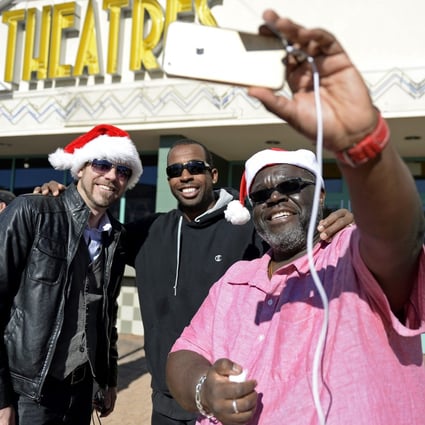 Movie goers Carlos Royal, right, Ryan Bergstrom, left, and Khai Ky-Yeith pose for a selfie as they attend the Christmas Day screening of "The Interview" in the Van Nuys section of Los Angeles, California December 25, 2014. Photo: Reuters