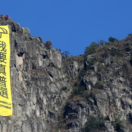 Another yellow banner is unfurled atop the famous Lion Rock. Like the one hoisted there in October, it carries the slogan 'I want genuine universal suffrage'. Photo: Nora Tam