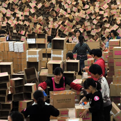Chinese workers package products from online orders at the warehouse of an online snack vendor in Changxing county, Zhejiang Province. Photo: ImagineChina 