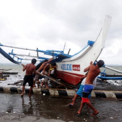 Fishermen move a boat in Legazpi as Typhoon Hagupit approaches. Photo: EPA