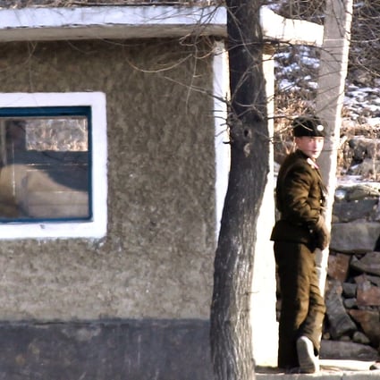 Two North Korean soldiers stand guard on the border with China. Photo: Simon Song