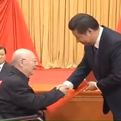 Yu Min (seated) is honoured by President Xi. Photo: SCMP Pictures