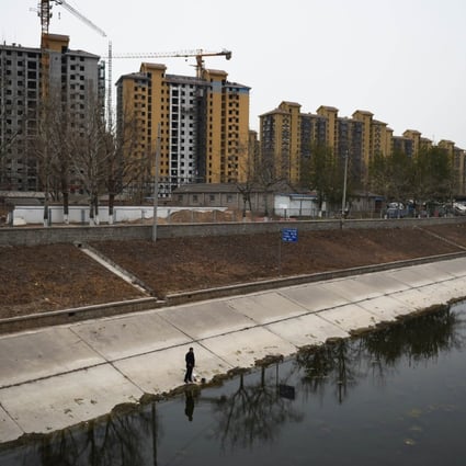 Newly built apartments dwarf a man fishing nearby in Beijing as land buying first-tier cities like the Chinese capital is seen staying strong. Photo: AFP