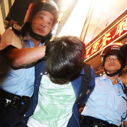 Police officers arrest a young pro-democracy protester in Mong Kok occupied site on November 26, 2014. Photo: Felix Wong