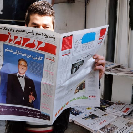 An Iranian man reads a copy of the January 13 edition of the reformist daily newspaper "Mardom-e Emrooz" featuring a photo of George Clooney with a headline reading "I am Charlie, too". Photo: EPA