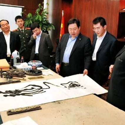 Disgraced former Chongqing police chief Wang Lijun (right) showed off his calligraphy work in 2010. 