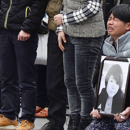 A man holds a portrait of a Shanghai stampede victim. Photo: AP