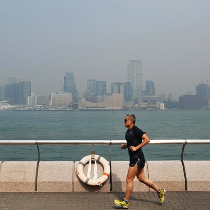 A runner ignores Wednesday's "serious" pollution level for a jog along the harbourfront on Hong Kong Island. Photo: Sam Tsang