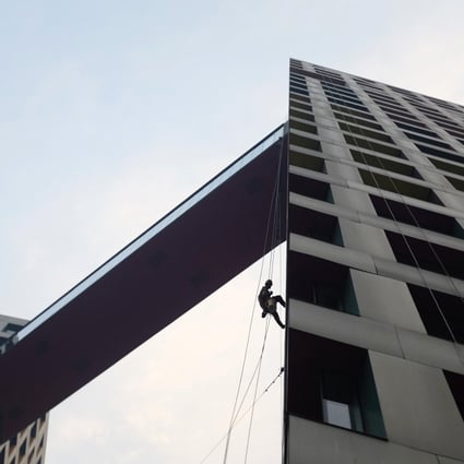 A worker cleans an apartment block in Beijing. The government is taking steps to reduce housing inventory. Photo: Reuters