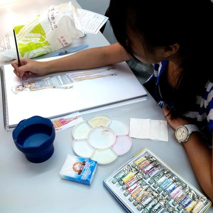 An Academy of Design student works on a sketch.