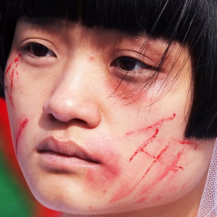A woman dresses up with bloody wedding gowns to campaign for domestic violence victims on Valentine's day in 2012. For safety reasons, women must seek short-term residence at shelters outside the district they live in and shelter locations are kept confidential. Photo: Simon Song