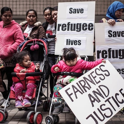 Asylum seekers along with their children stage a protest for their rights in Hong Kong on February 6, 2015, following the recent death of one of them during a fire that broke in a slum. Photo: AFP