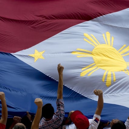 Protesters carry the national flag in Manila. President Benigno Aquino is under increasing pressure to step down over a botched anti-terror operation. Photo: AFP