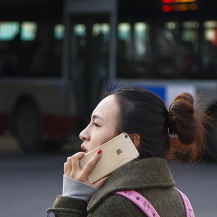 A woman speaks on her iPhone in Beijing. China has removed Apple from its list of approved state procurement vendors. Photo: EPA