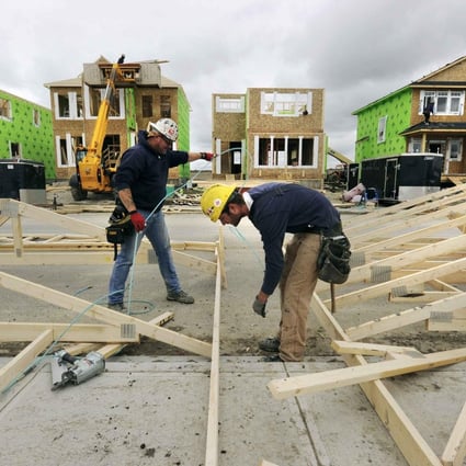 Construction workers build homes in Calgary. Buyers are hoping for a real estate slump. Photo: Reuters