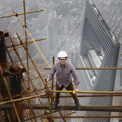 Architect Danny Forster, the host of "How China Works", a three-part series that will air on The Discovery Channel, stands on building scaffolding high above Shanghai. Photo: AFP