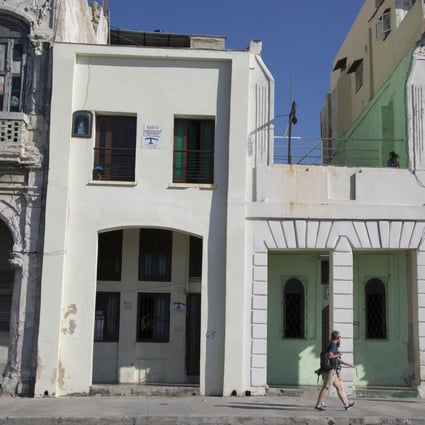 Tourists walk past houses with rooms for rent in Havana. Airbnb now allows licensed American travellers to book lodgings in Cuba. Photo: AP