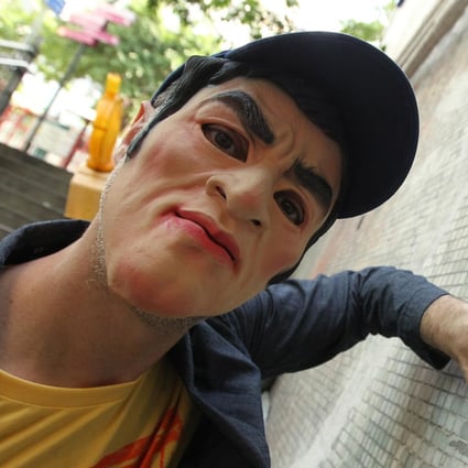 French artist Invader wearing a mask poses for a photograph on Hollywood Road. Photo: Franke Tsang