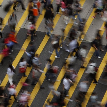 People cross a street in Mong Kok district in Hong Kong. Photo: Reuters