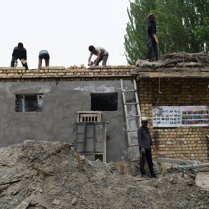 Workers build a house in the town of Elishku, Xinjiang. The township was the scene of a bloody clash in July 2014. Photo: AFP