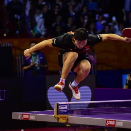 Ma Long jumps on the table after becoming world champion for the first time by beating Fang Bo in the final. Photo: Xinhua