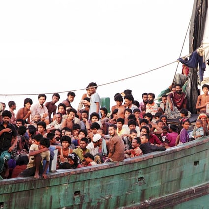 Rohingya and Bangladeshi migrants wait on board a fishing boat before being transported to shore, off the coast of Julok, Indonesia, on Wednesday. Photo: Reuters