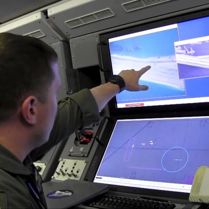 A US Navy crewman aboard a P-8A Poseidon surveillance aircraft views a computer screen purportedly showing Chinese construction on the reclaimed land of Fiery Cross Reef in the disputed Spratly Islands. Photo: Reuters