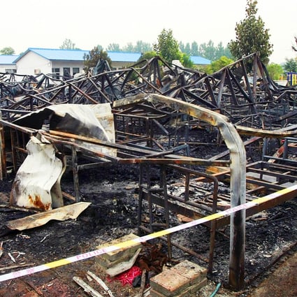 Police and inspectors examine the scene of the blaze in Henan province. Photo: EPA