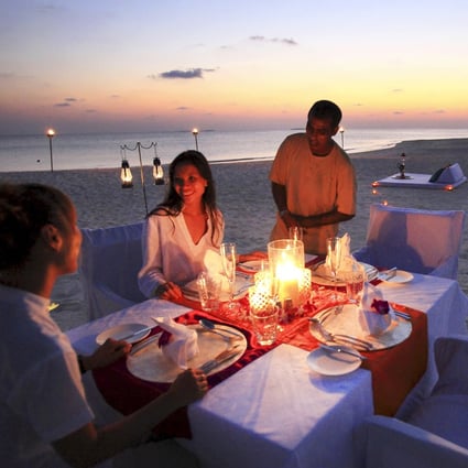Chinese tourists having a beach private dinner at the Kanuhura luxury hotel, Maldives islands.