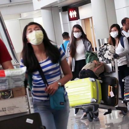 Travellers don masks at Chek Lap Kok airport. Photo: Felix Wong