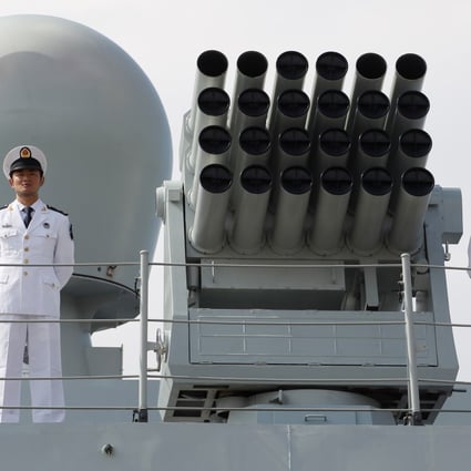 Officers from the People's Liberation Army Navy stand at attention on board a naval guided missile destroyer. File Picture